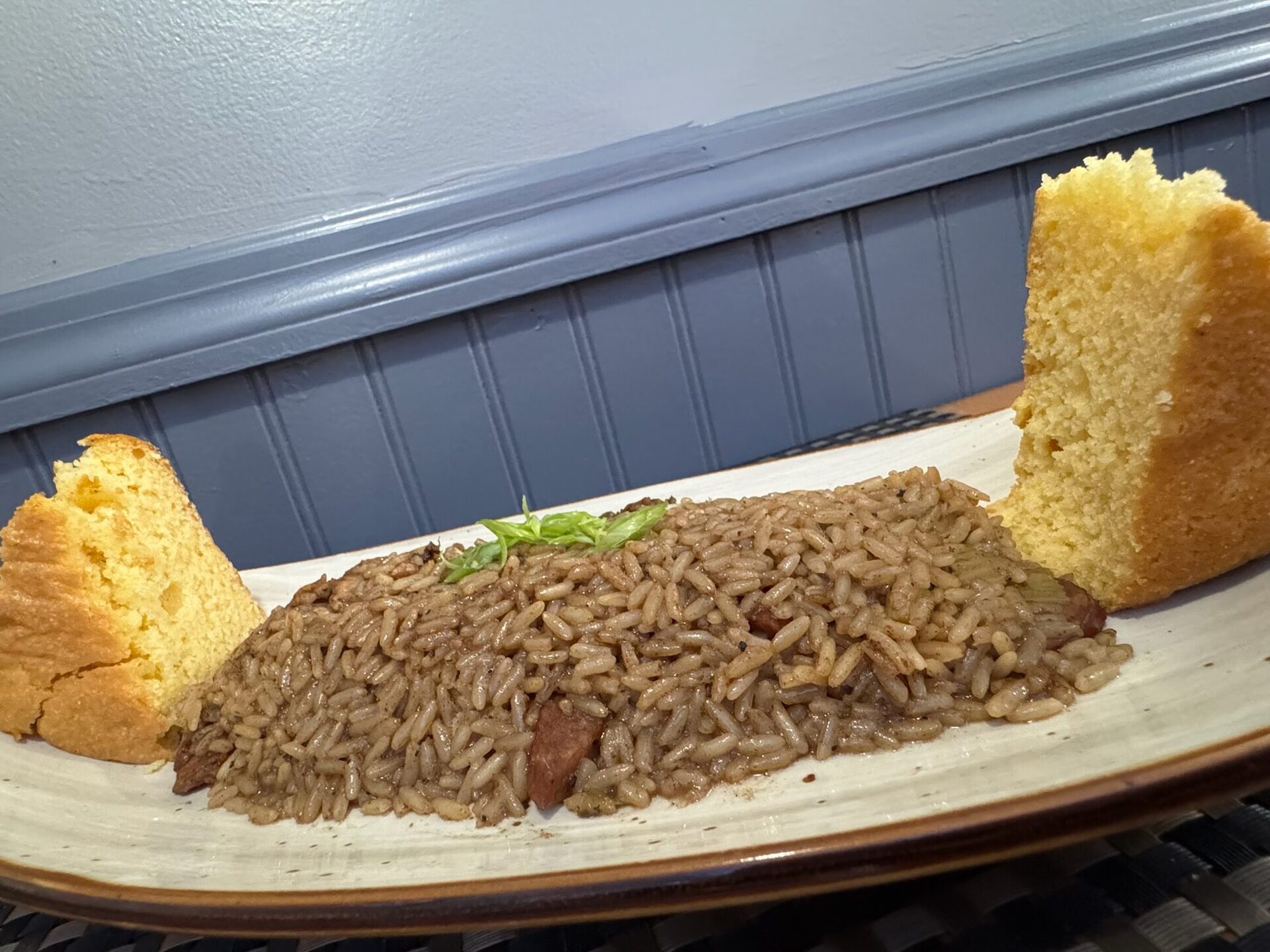 Jambalaya with dirty rice and two squares of golden cornbread