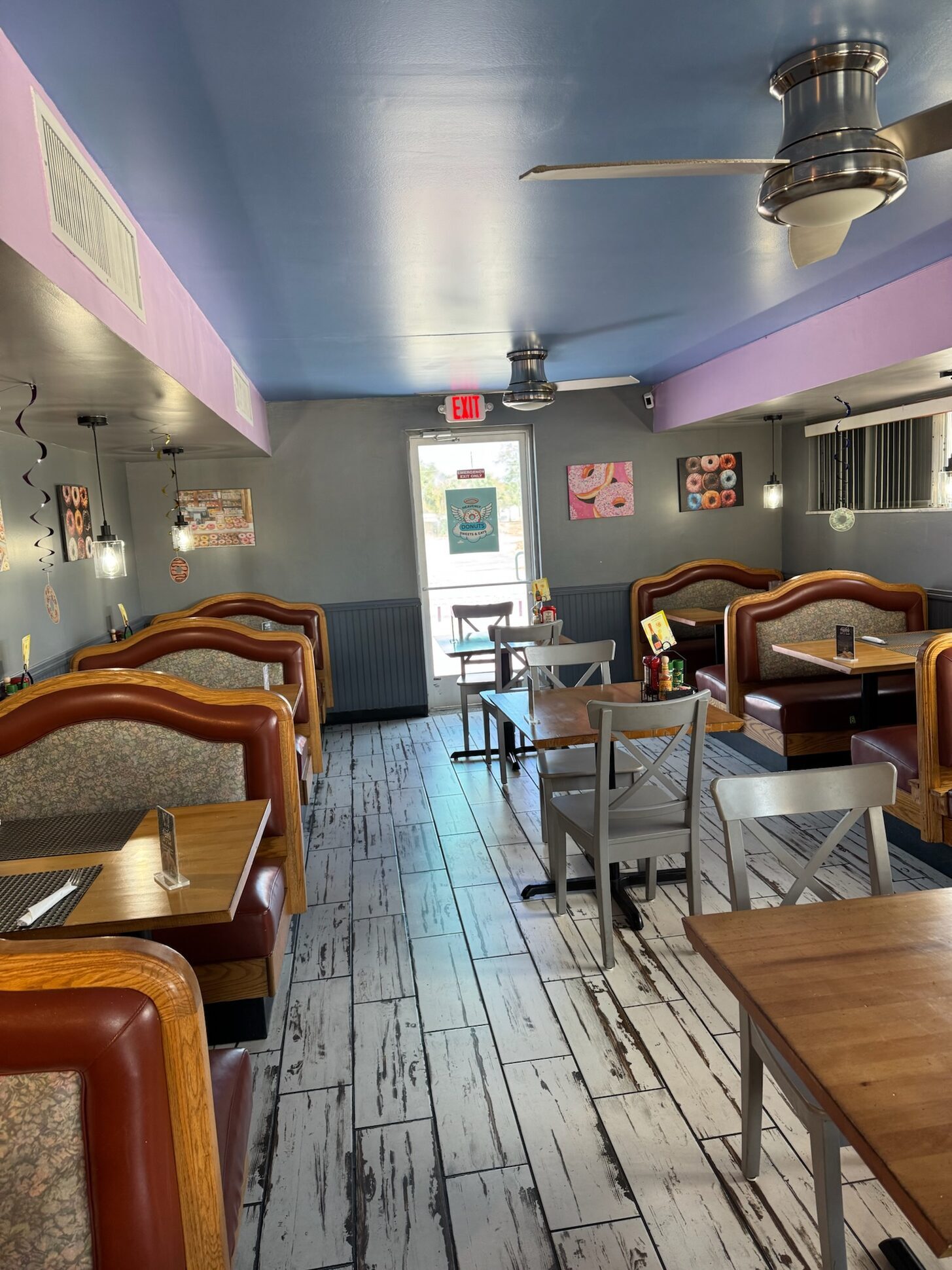 The dining room with sky-blue ceiling, leather booths, and donut art on the walls