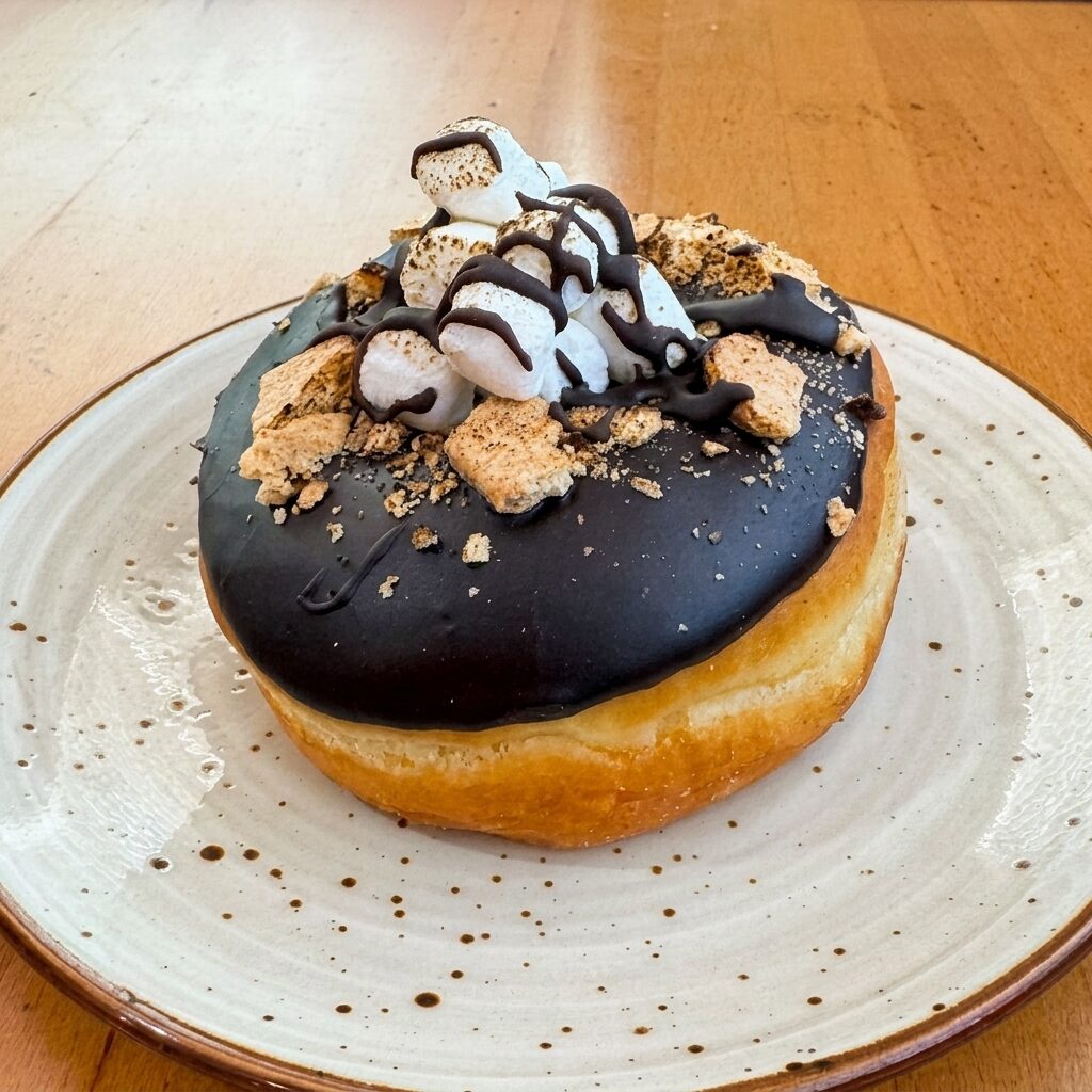 S'mores donut with dark chocolate glaze, marshmallows, and graham cracker