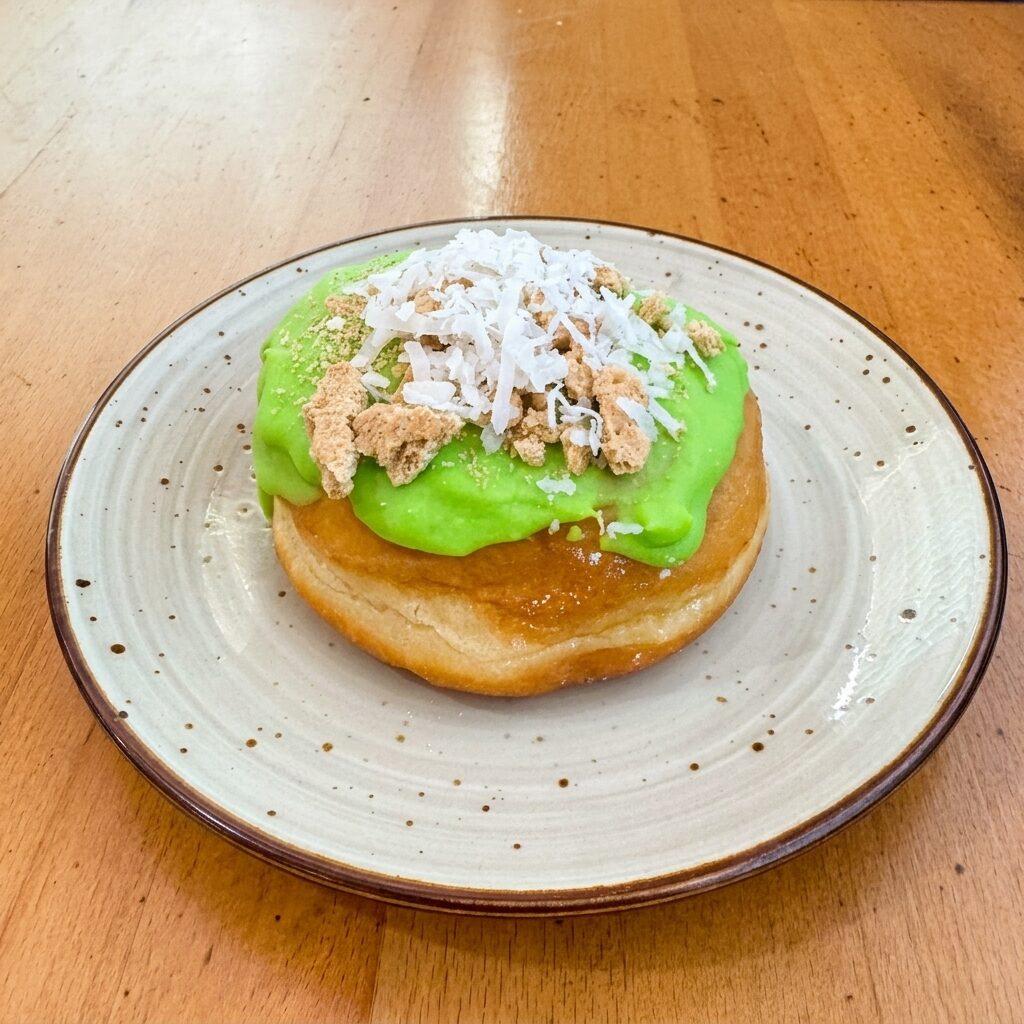 Coconut lime donut with lime-green frosting and coconut flakes